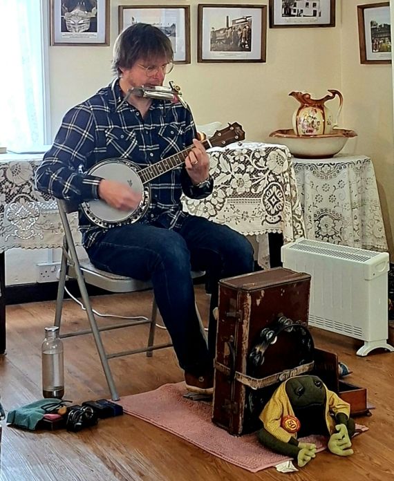 David Mooney playing the Banjo in his house.